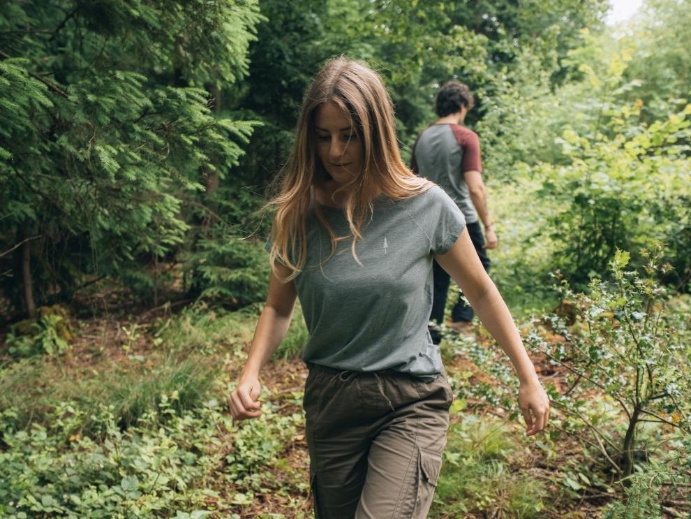 Unterwegs im Wald, eine Frau und ein Mann im NIKIN TreeShirt Coffee Carbon.